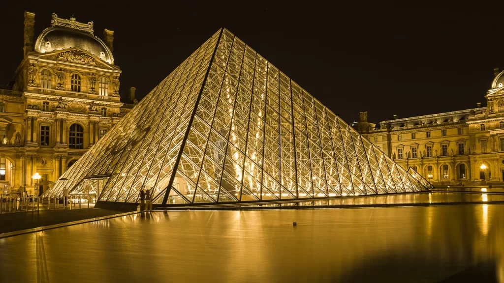 The pyramid and buildings of the Louvre lit up beautifully at night