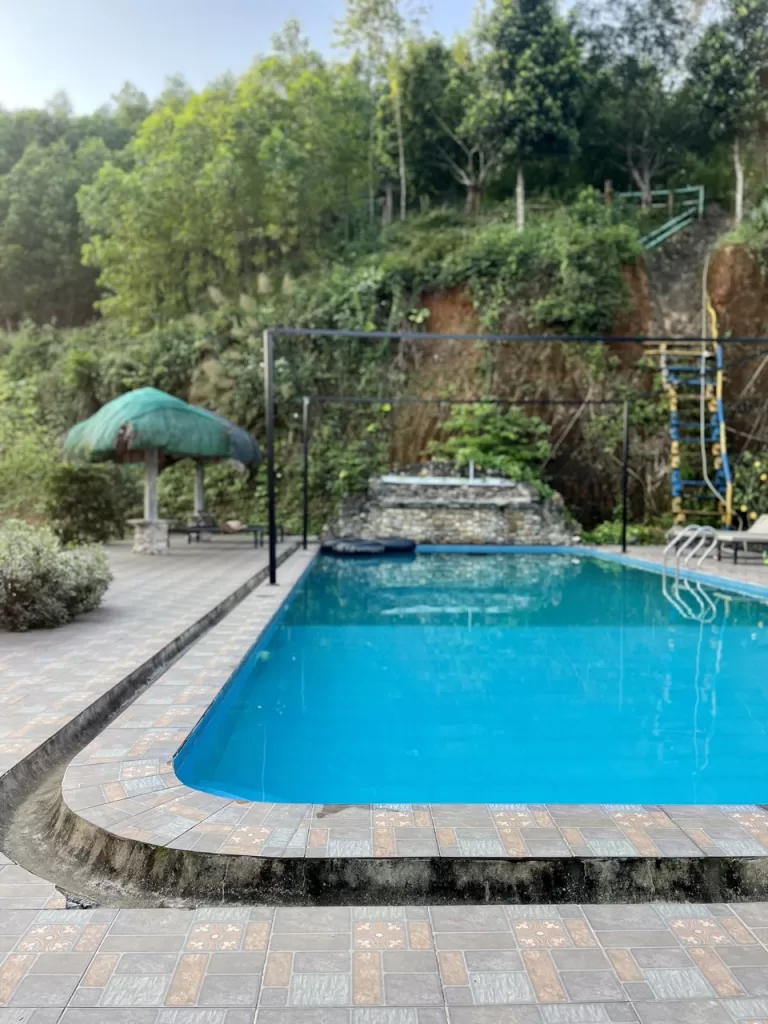 pool with bar tables and chairs on the side
