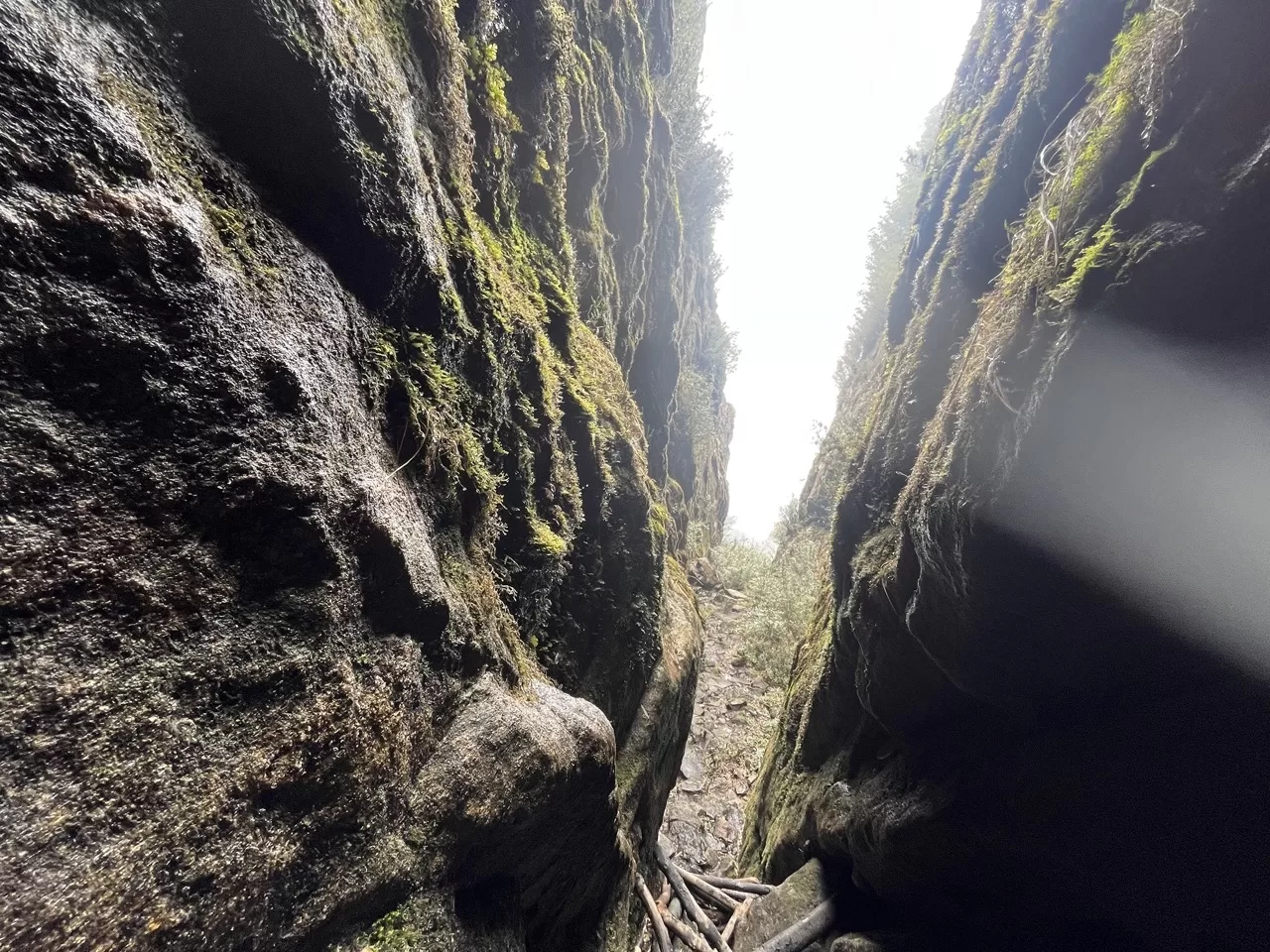 narrow opening between two mountain faces with ladders to climb up the steep path in the middle
