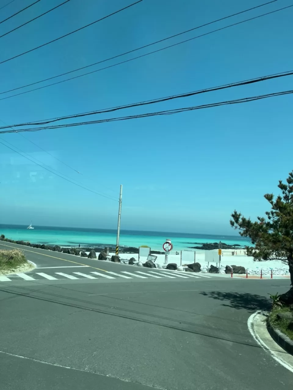 bright blue waters of a beach visible from the road