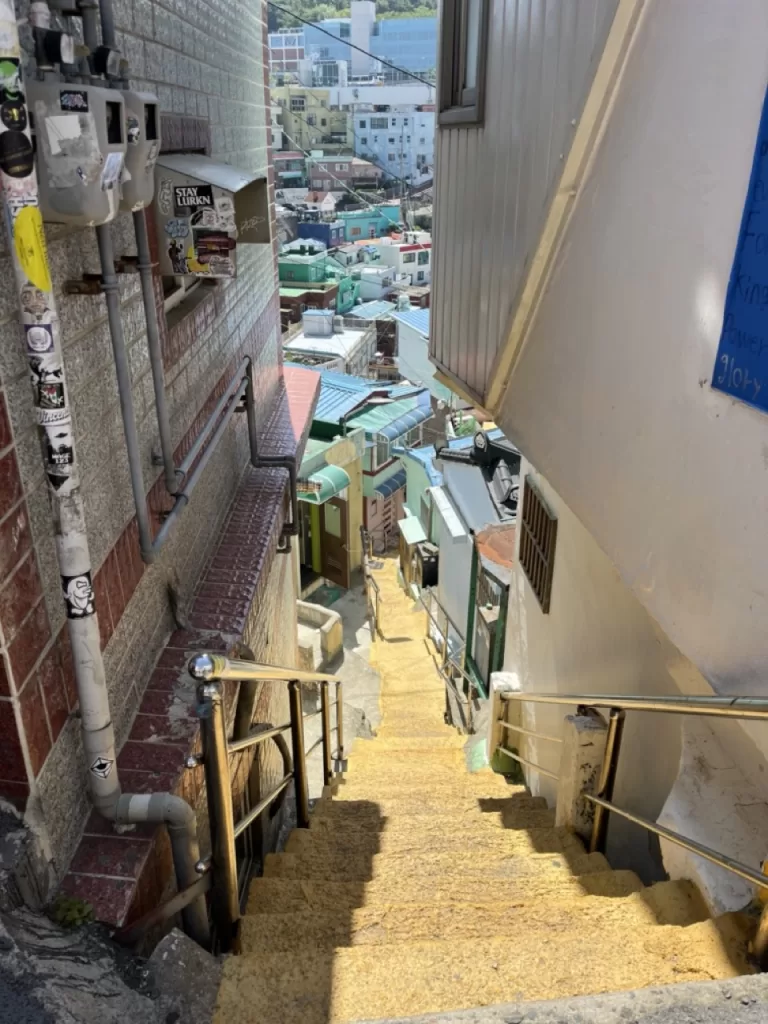 steep, narrow staircase going down a village road with small multicolored homes on the side