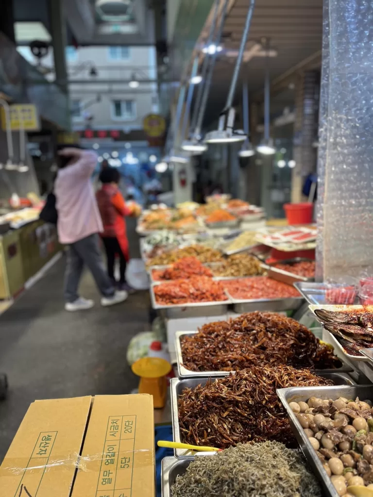 trays filled to the top with multicolored and varied seafood and kimchis at a market in Busan